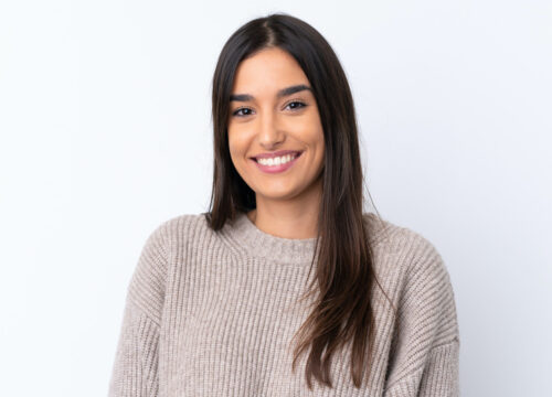Photo of a smiling woman wearing a sweater against a white background