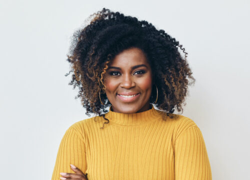 Photo of a smiling woman wearing a yellow sweater