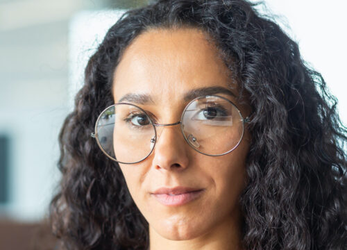 Photo of a serious-looking woman wearing glasses