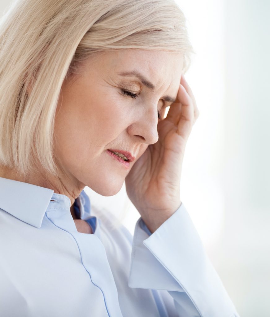 Woman with a headache due to hormonal imbalanace